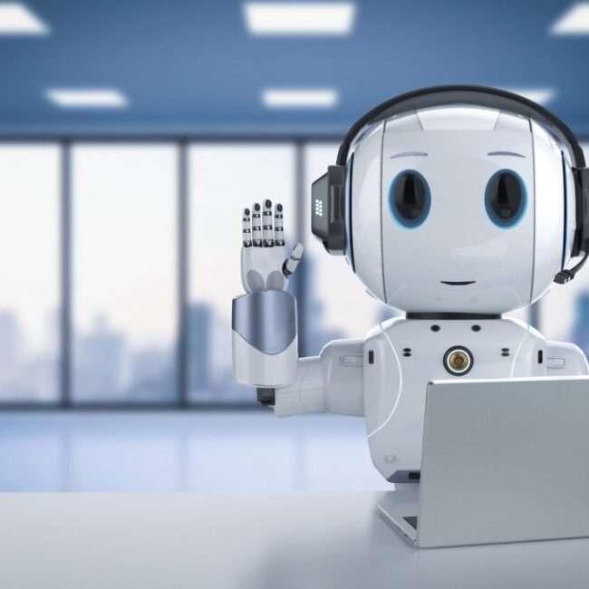Robot humanoide de sobremesa junto a un portátil en un espacio de oficina luminoso