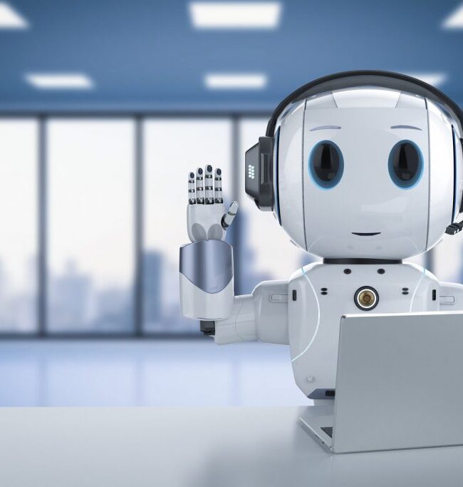 Robot humanoide de sobremesa junto a un portátil en un espacio de oficina luminoso
