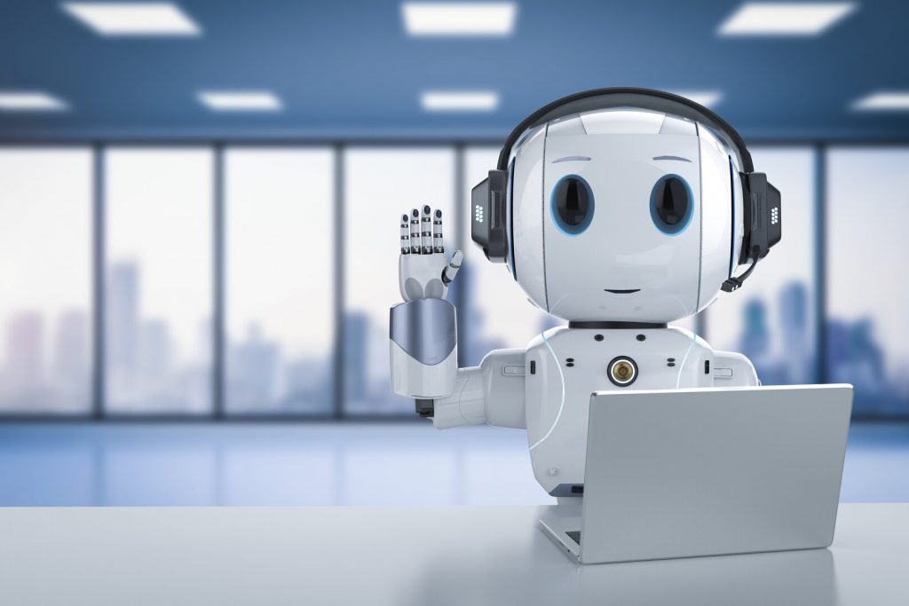 Robot humanoide de sobremesa junto a un portátil en un espacio de oficina luminoso